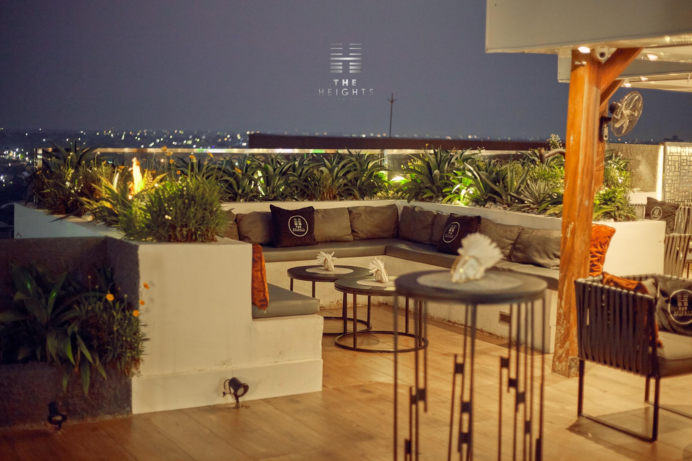 The Heights rooftop lounge at night, with Kumasi's lights beyond the planters
